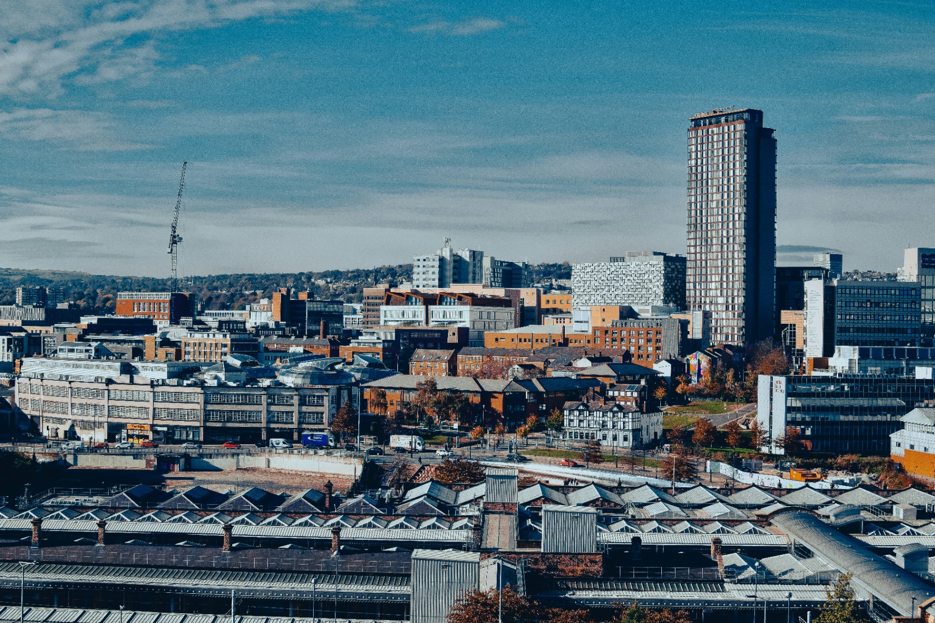 Sheffield city skyline with St Paul's Tower and the Cheesegrater car park beside Sheffield Station's arched roofs